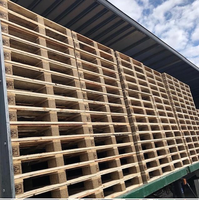 Wooden pallets loaded inside a curtain-sided trailer