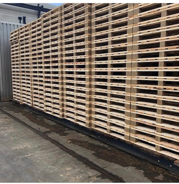 Rows of stacked wooden pallets on a trailer